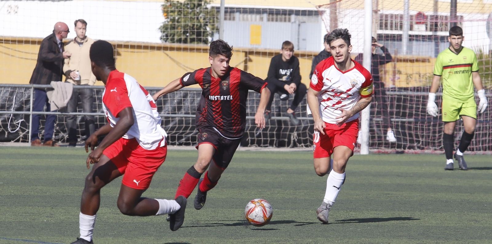El rojinegro Alvarito controla ante la presencia de dos jugadores del Almería.