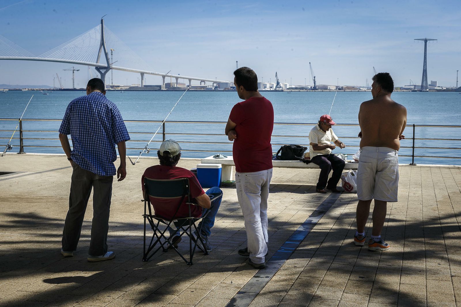 Varios ciudadanos pescan en el Paseo de la Bahía.