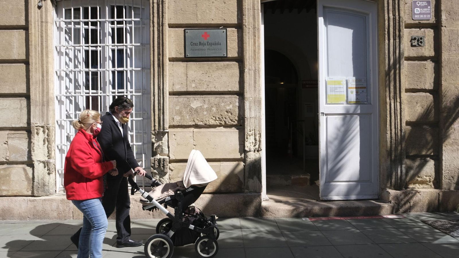 Carlos pasea a su bebé de acogida junto a la responsable del programa en Cruz Roja.