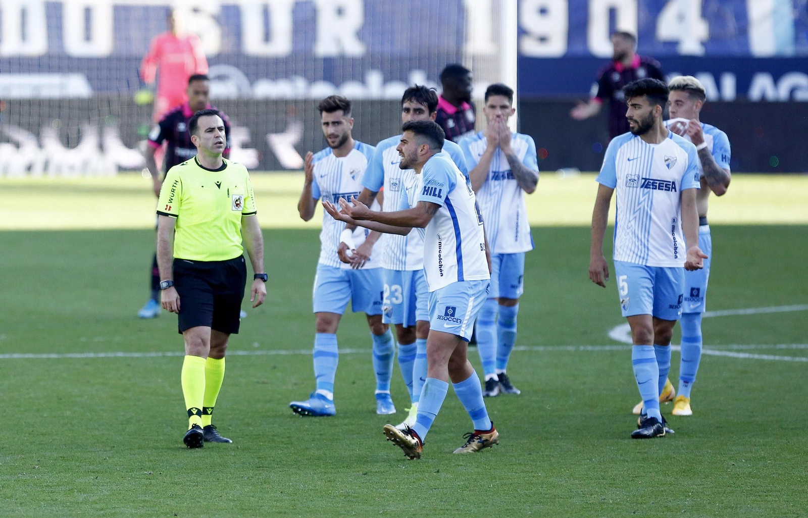 Los jugadores del Málaga protestan al colegiado en el Málaga-Tenerife.