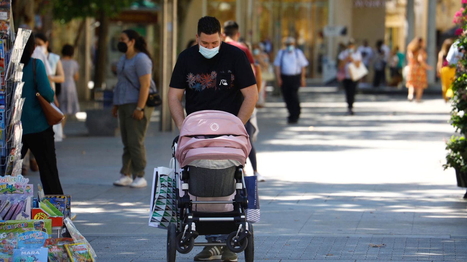 Un hombre pasea a un bebé en un cochecito.