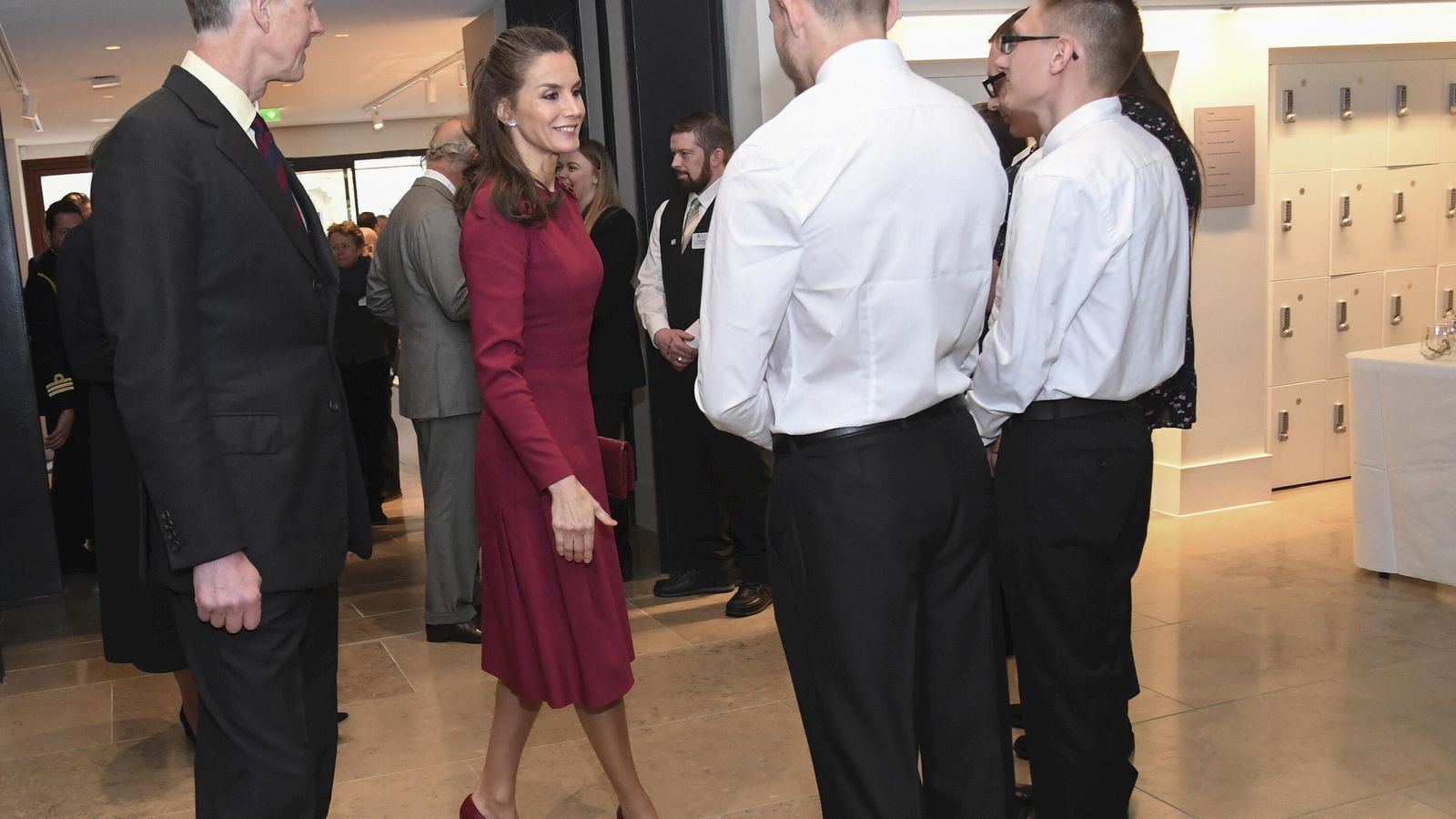 La Reina, con su vestido de Carolina Herrera rojo vino.