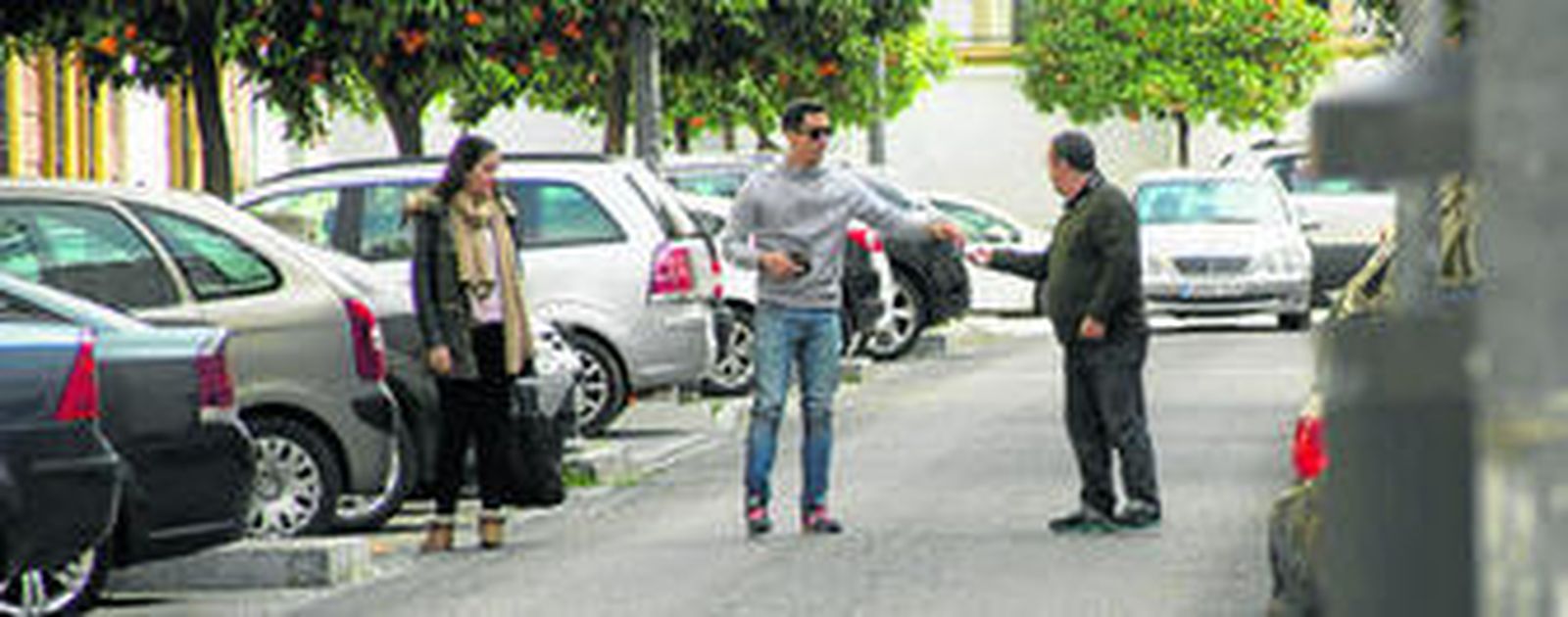 Un conductor entrega una moneda a un 'gorrilla', el pasado viernes en la calle Manuel Casana.