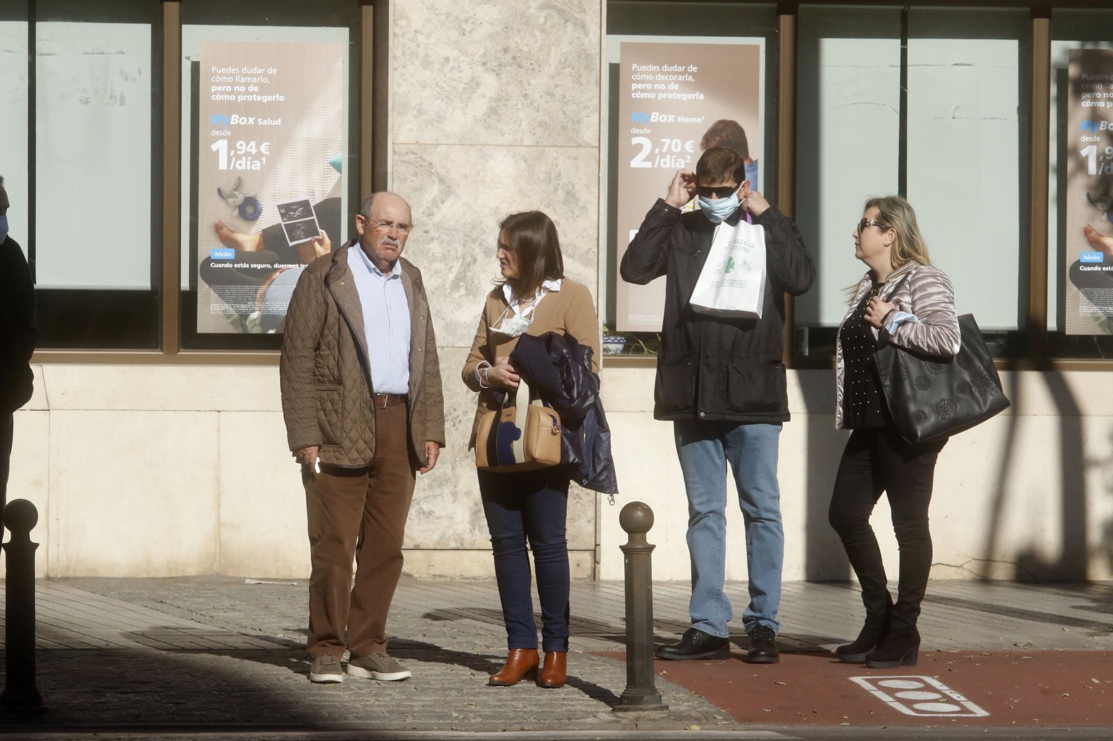 Varias personas esperan en un paso de peatones de la avenida del Aeropuerto.
