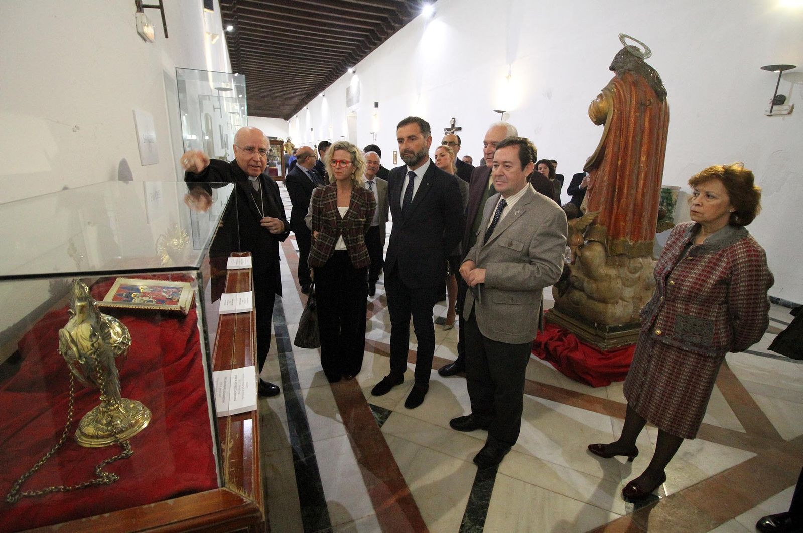El obispo da explicaciones a los asistentes a la inauguración de la muestra.