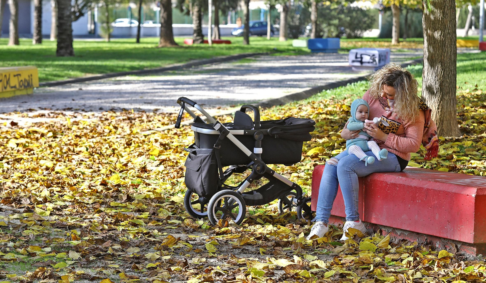 Una joven con su bebé, en un parque de la ciudad.