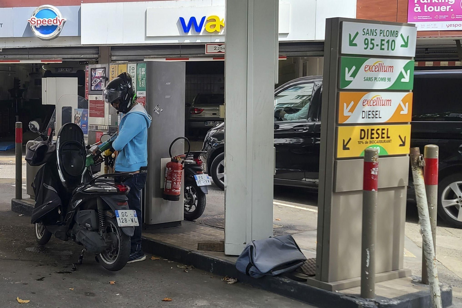 Una persona reposta su motocicleta en una gasolinera