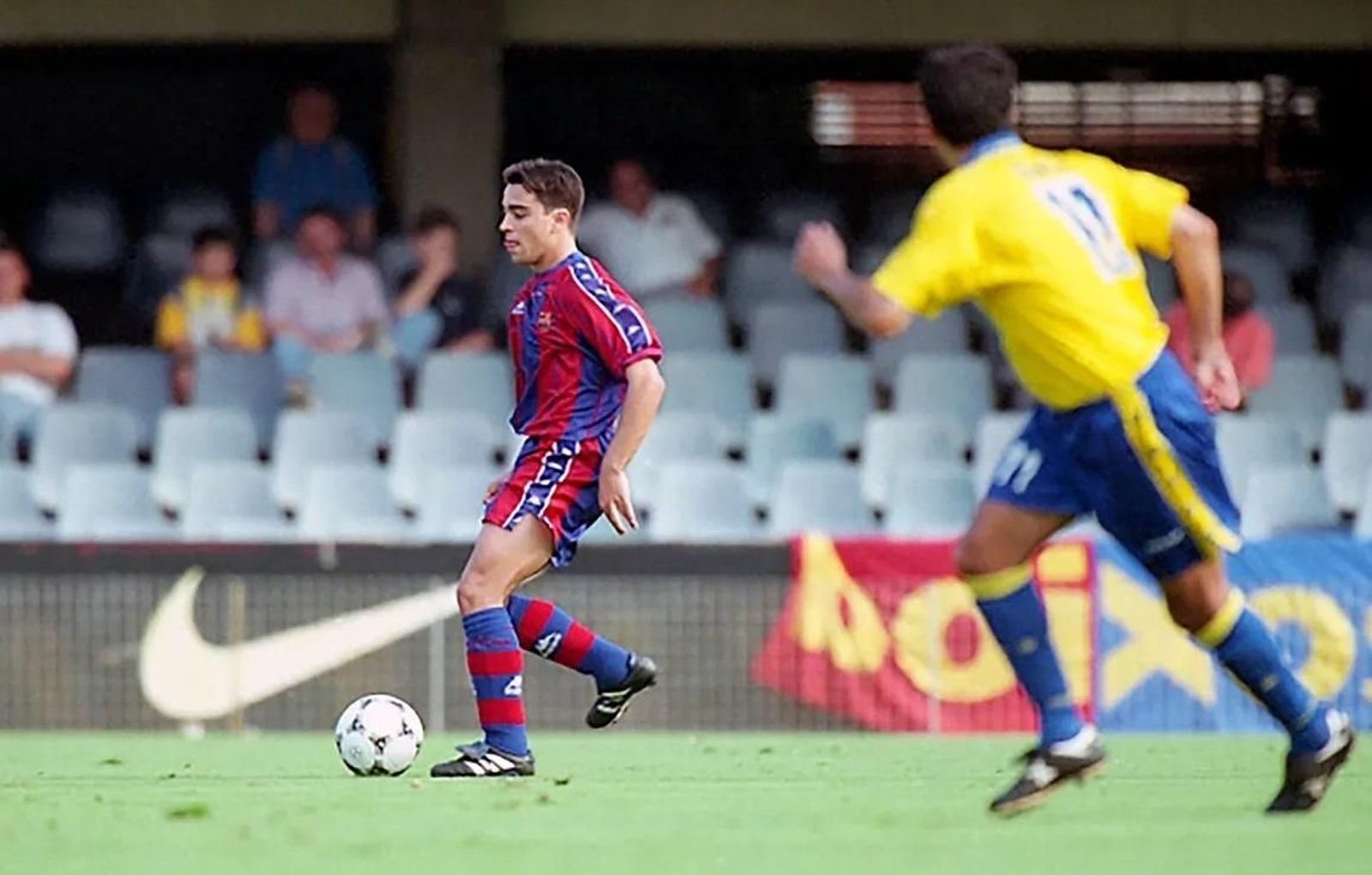 Xavi avanza con el balón mientras lo observa Barla, en el Barça B-Cádiz de 1998.