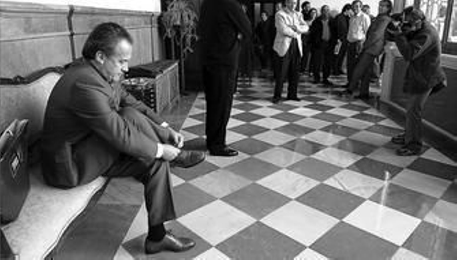 Pedro Pacheco se ata los cordones de los zapatos antes de entrar en la sala en la que se juzgaba la expropiación de Los Garciagos en Granada, en 2001.