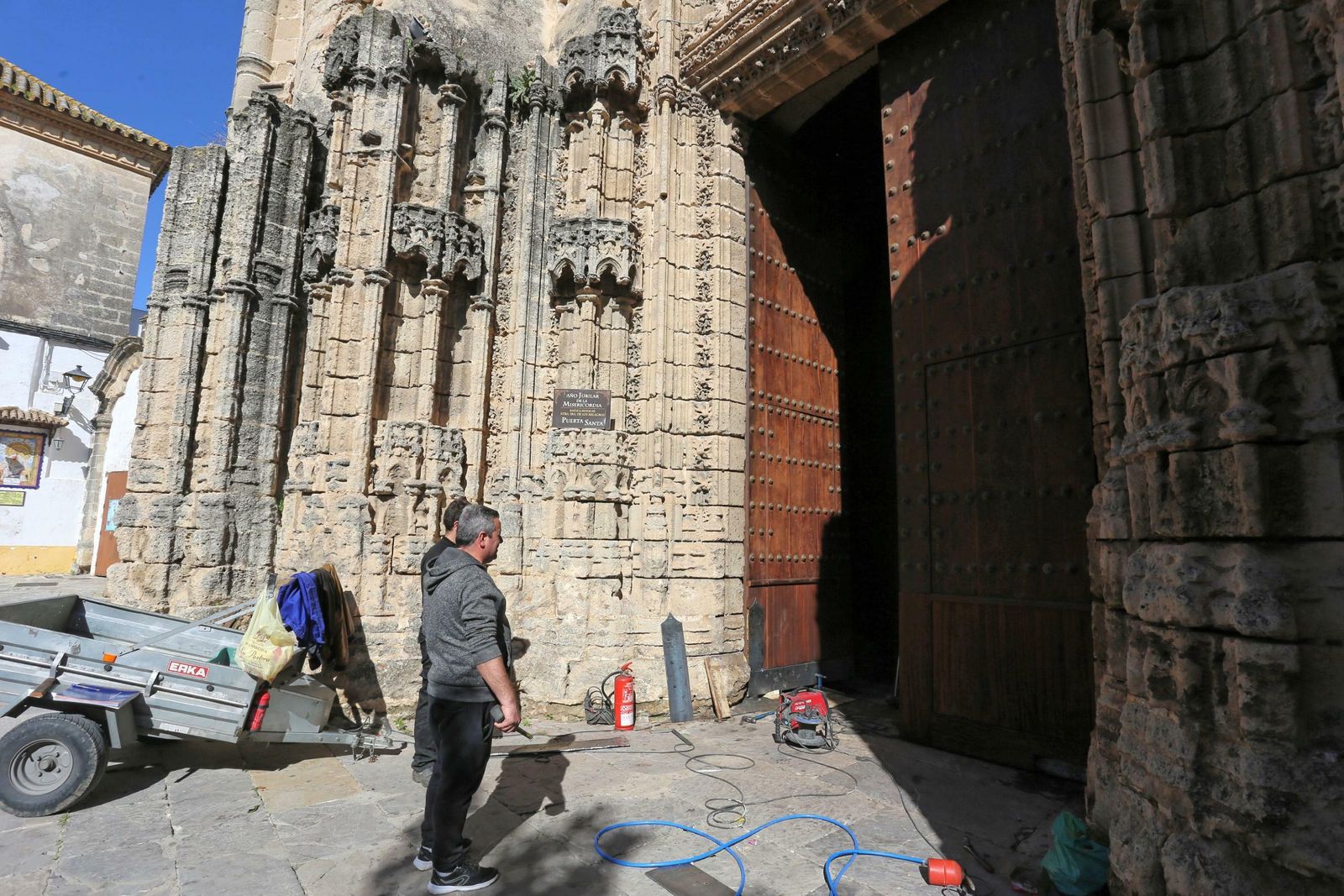 Imagen de dos de los restauradores que trabajan actualmente en la puerta del Perdón.