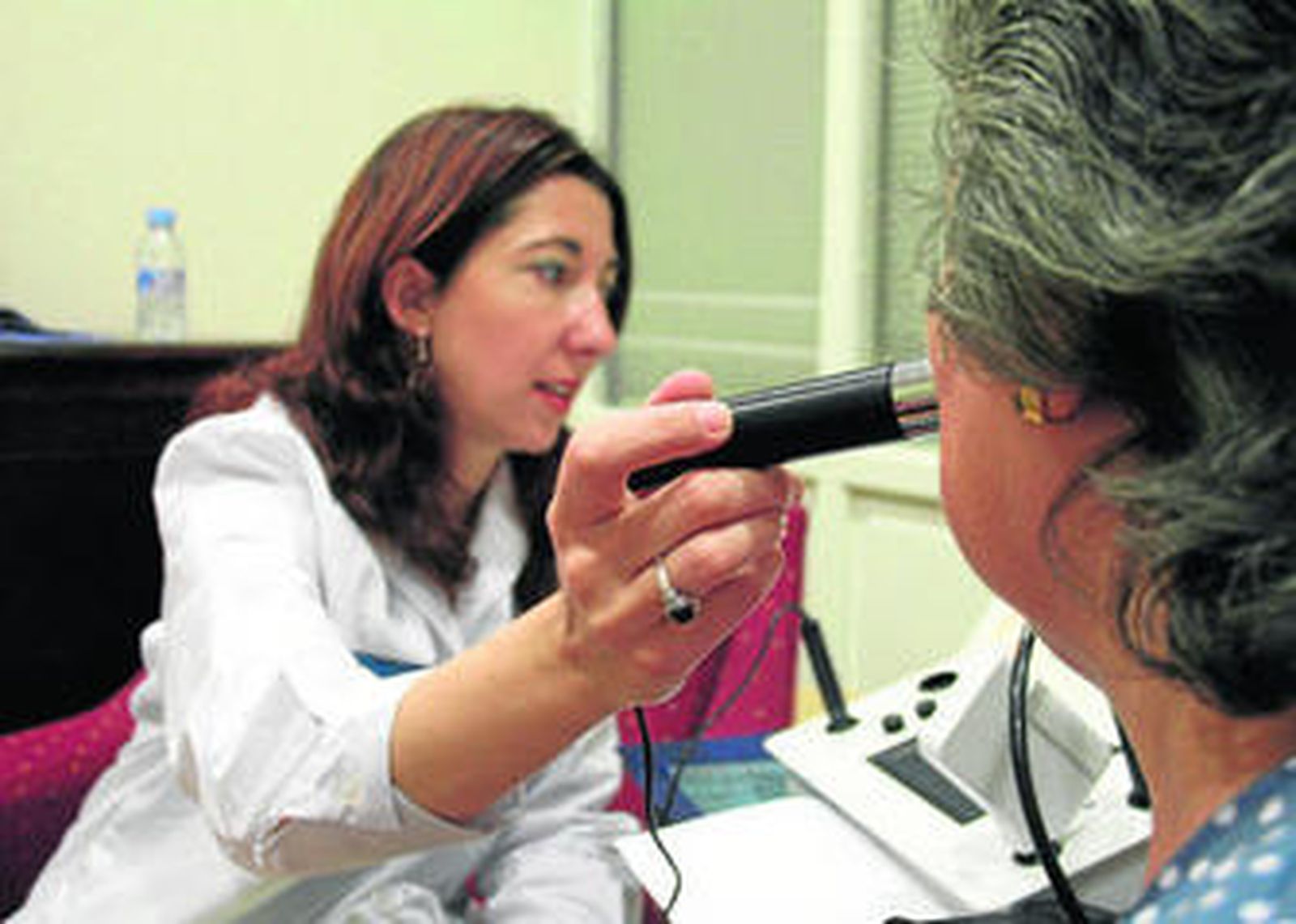 Una especialista realiza un examen de piel a una mujer.