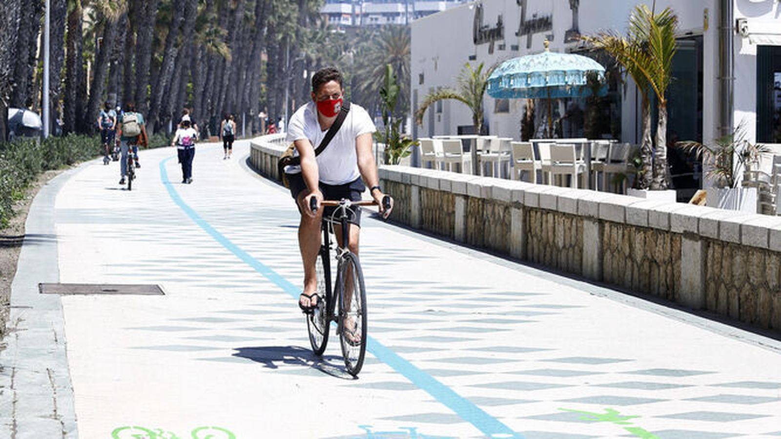 Un ciclista circula por el carril provisional delimitado por el Ayuntamiento en el paseo marítimo Picasso.