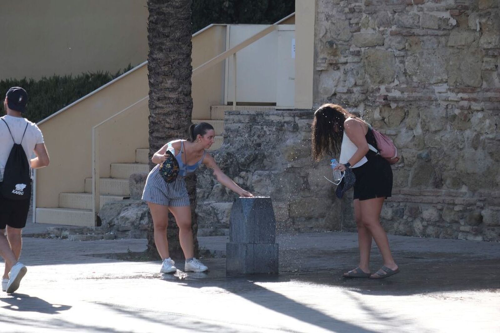 Dos jóvenes se refrescan en una fuente de Córdoba.