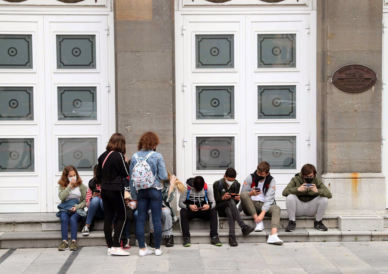Un grupo de jóvenes con mascarilla  a la entrada del Teatro Campoamor en Oviedo.