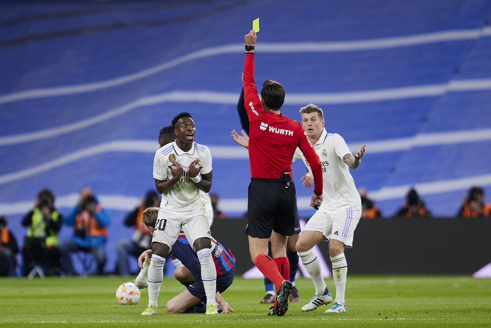 Munuera Montero le muestra la tarjeta amarilla a Vinícius tras su acción con De Jong.
