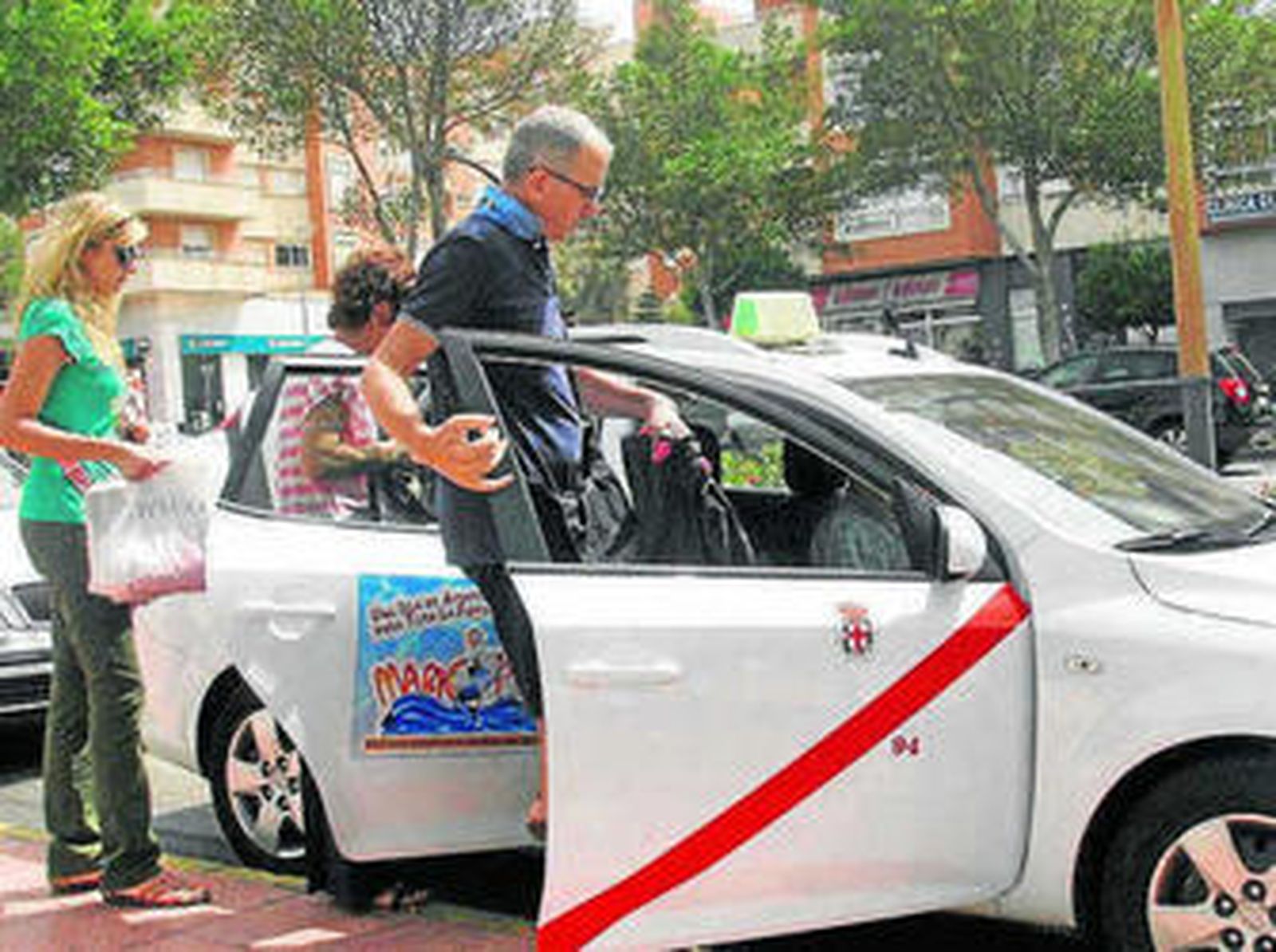 Una familia coge un taxi de la capital en la Avenida del Mediterráneo.