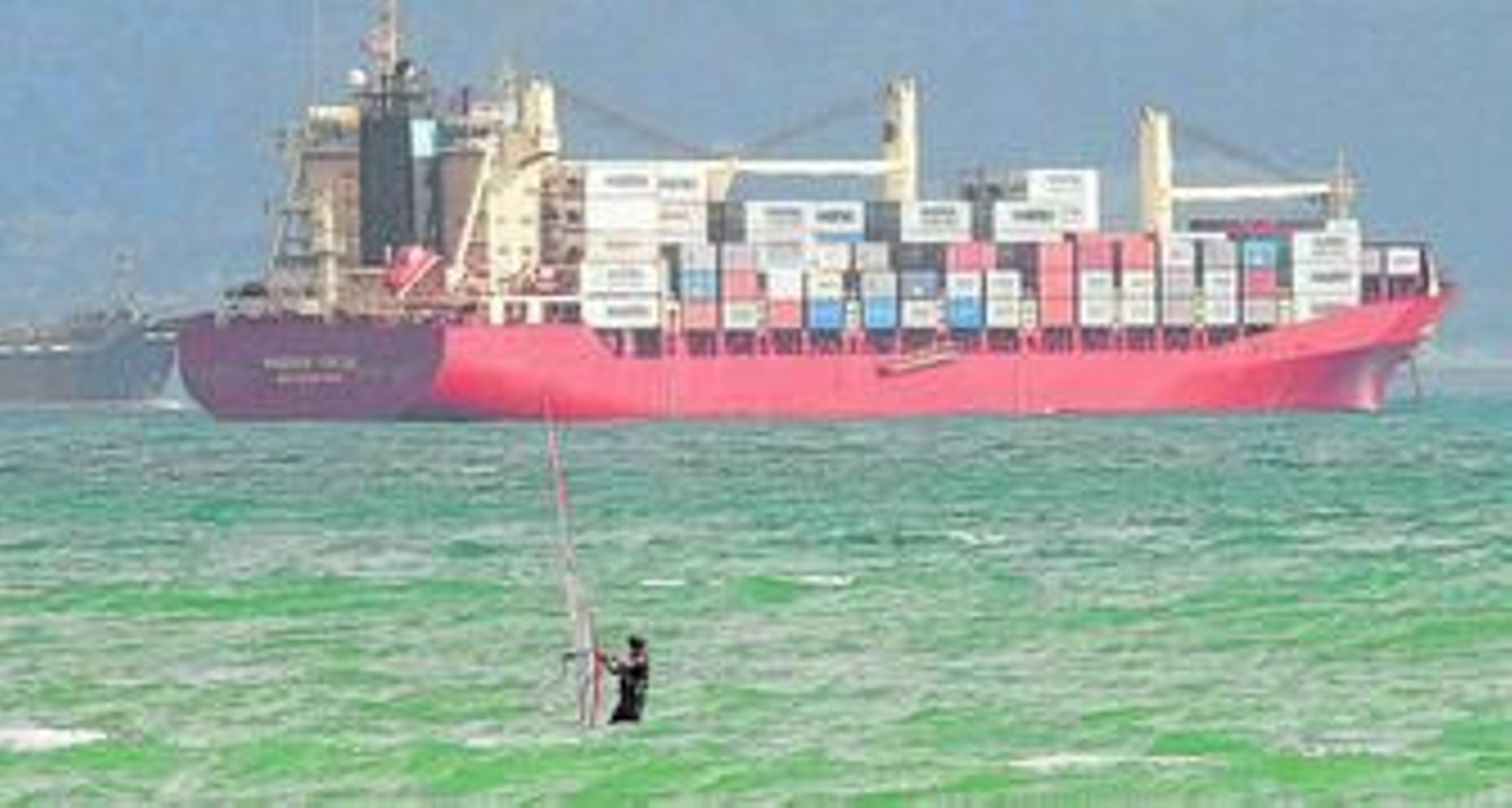Un surfista navega en la Bahía de Algeciras cerca de un portacontenedores, en una imagen de archivo.