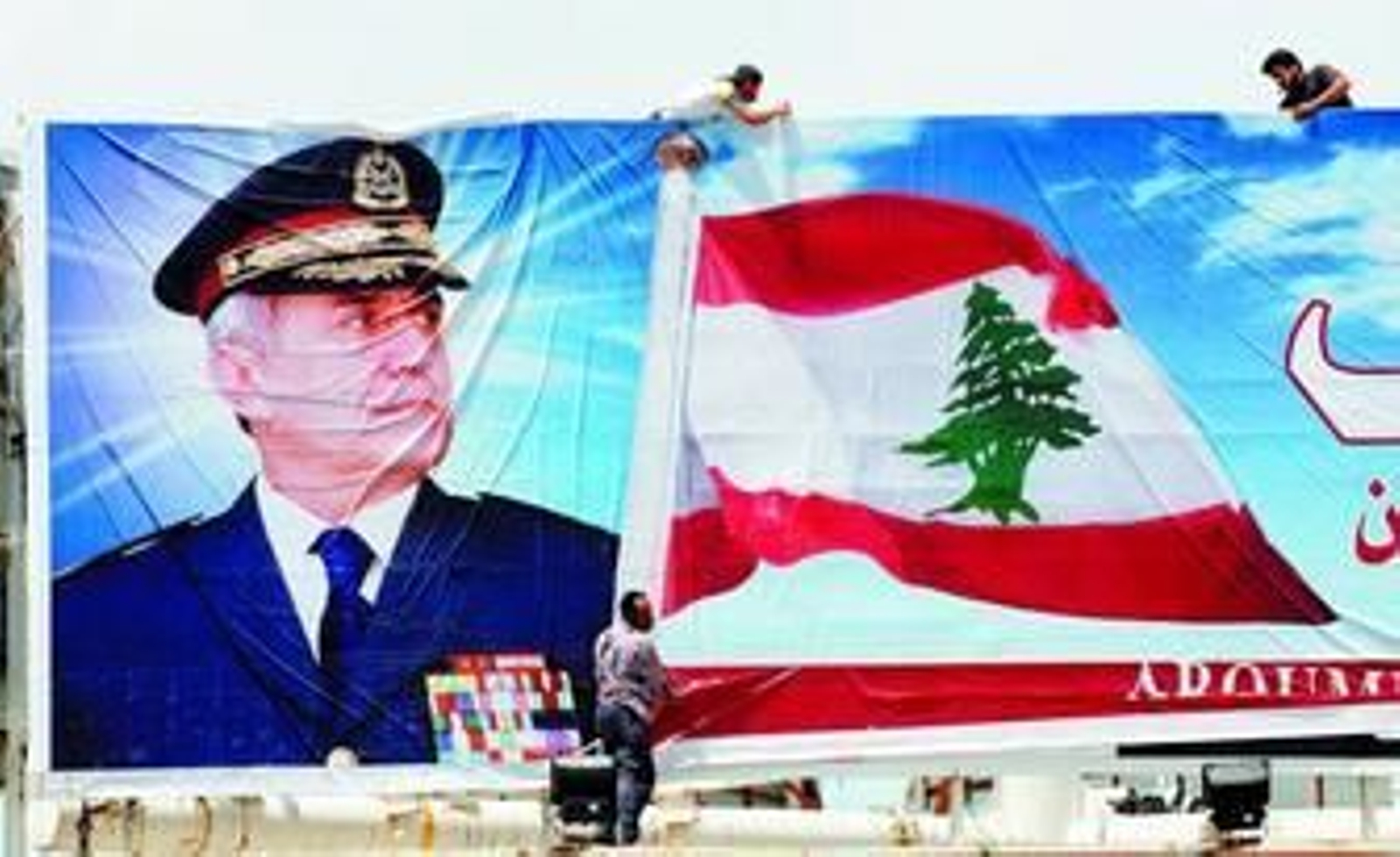Unos trabajadores colocan un póster del general Michel Suleiman en Beirut.