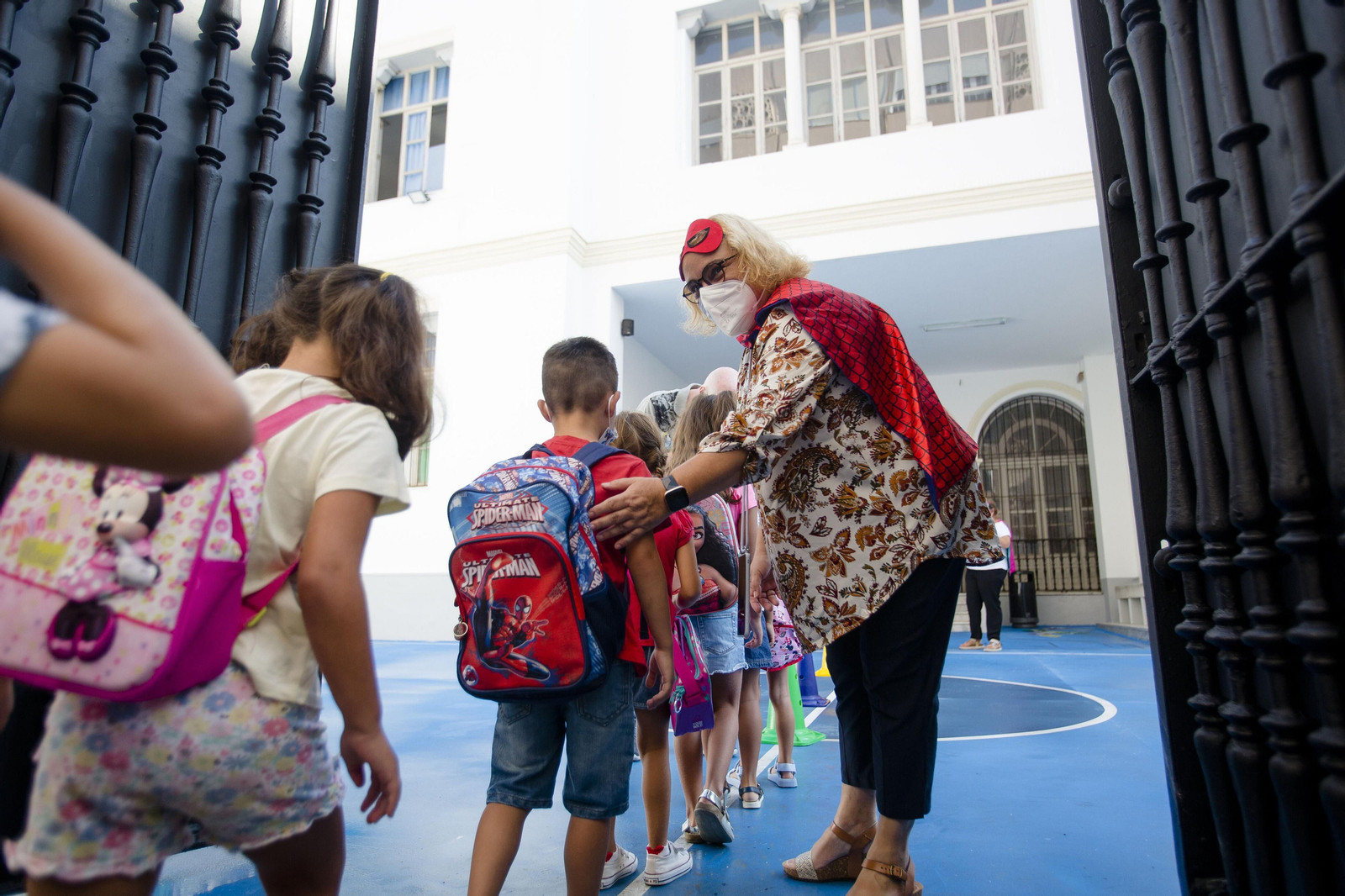 Una profesora con capa y antifaz de Spiderman recibe a los alumnos del CEIP San Rafael.