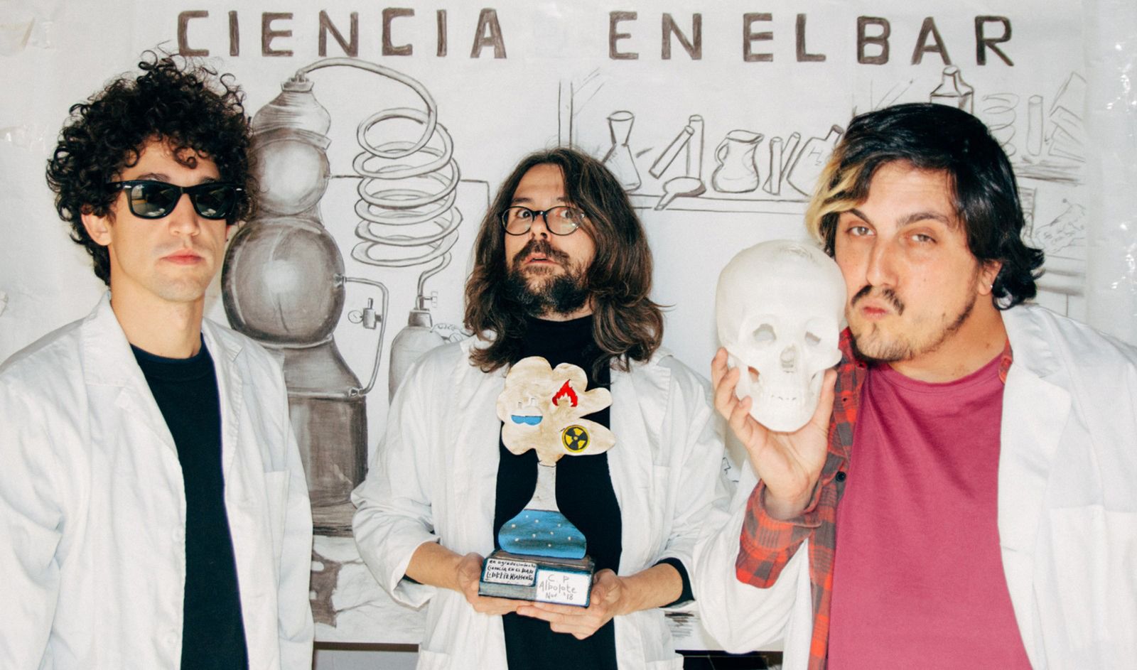 Los integrantes de Ciencia en el bar posan con un mural hecho por presos de la Cárcel de Albolote