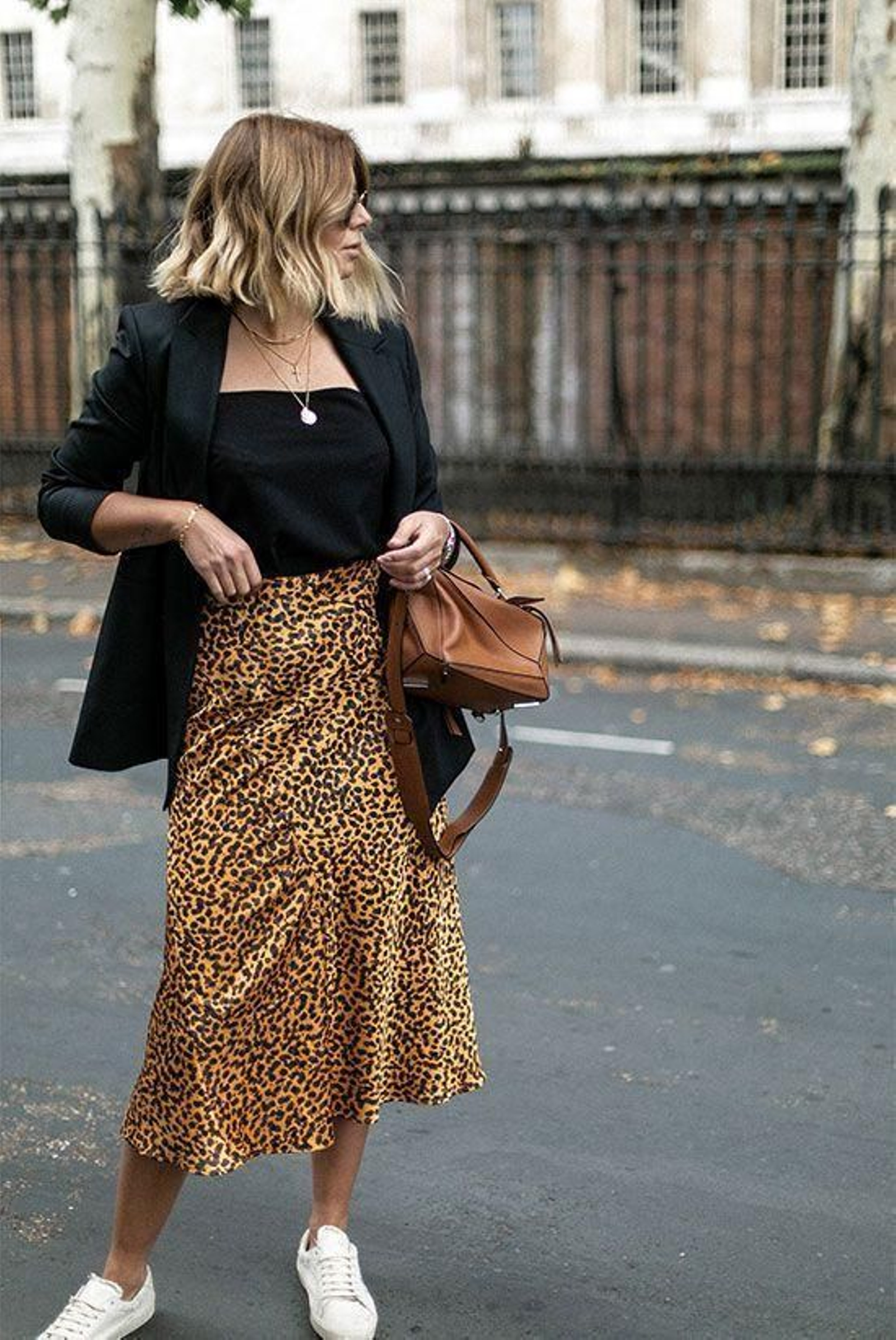 Look con falda en animal print, zapatillas deportivas y blazer.