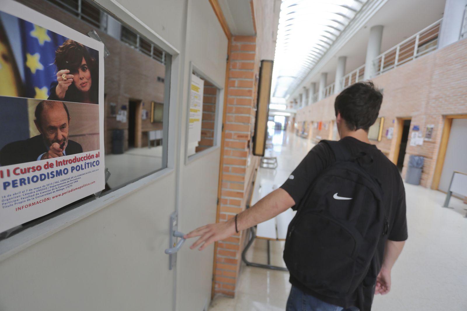 Un alumno caminando por un pasillo de la Facultad de Ciencias de la Comunicación.