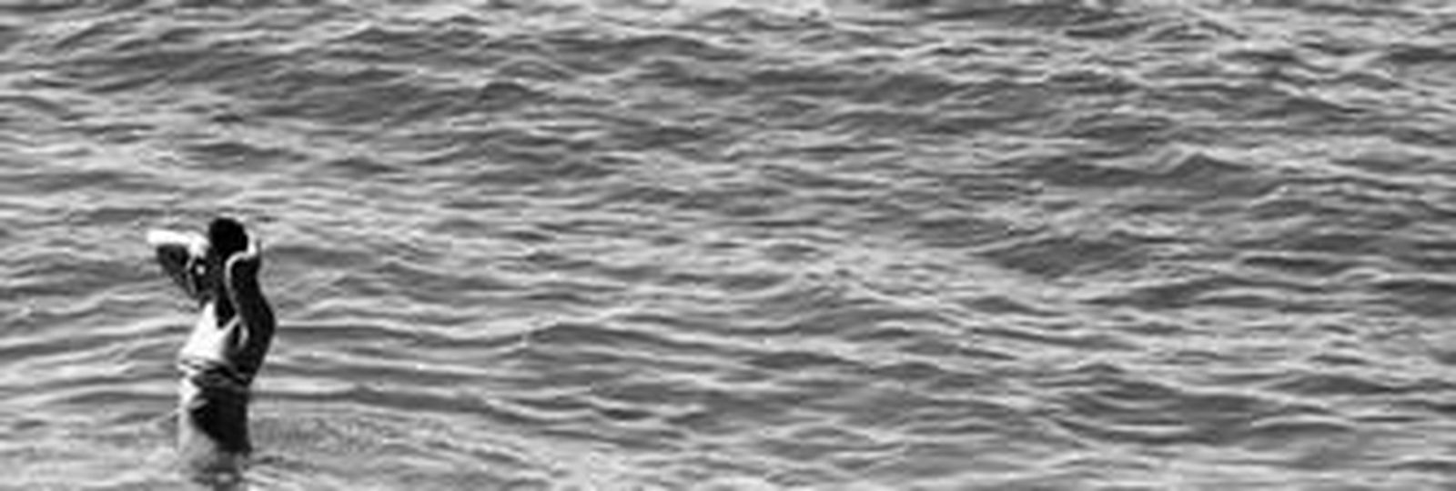 Una mujer se baña, ayer, en la playa de los Baños del Carmen.