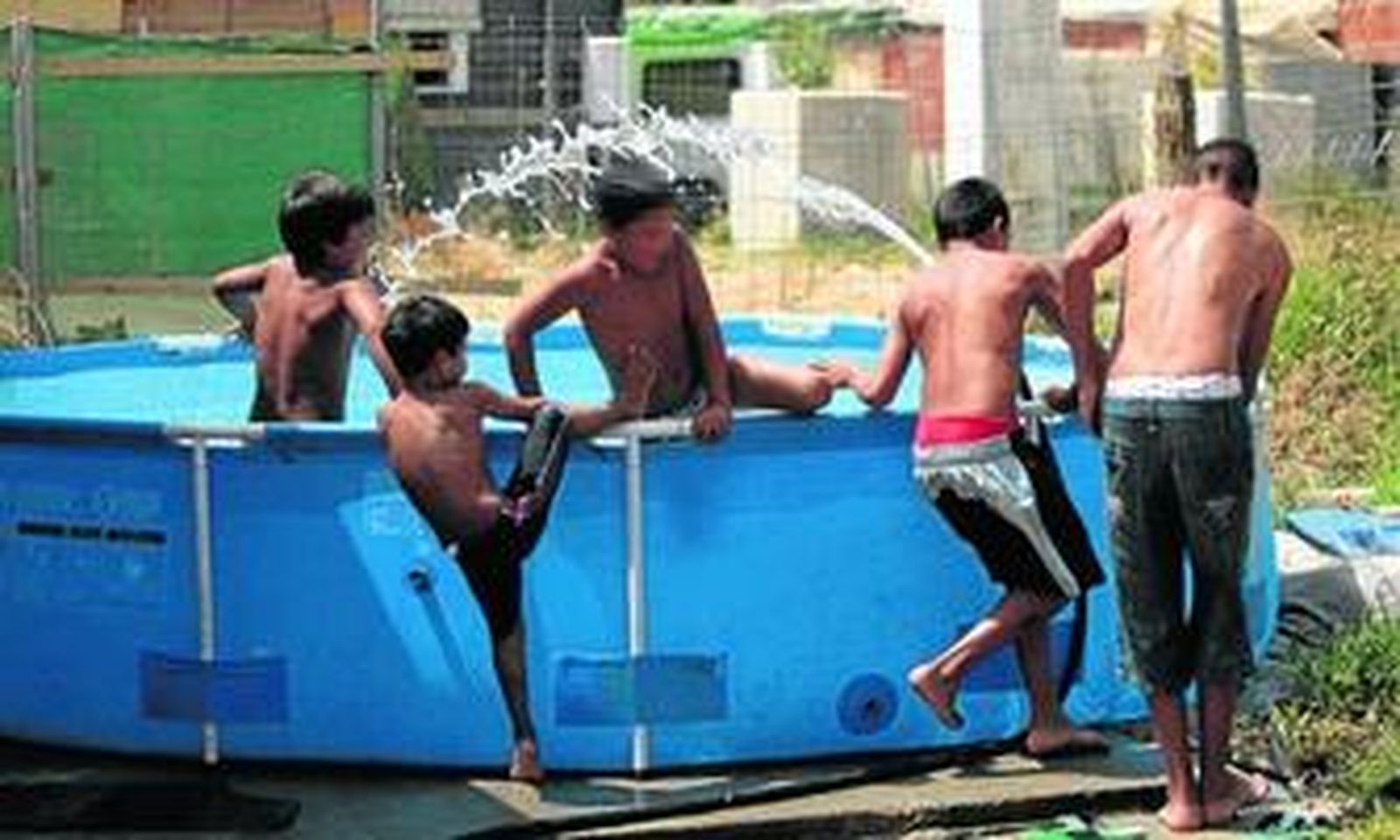 Varios niños se bañan en una piscina portátil en mitad del asentamiento chabolista del Vacie, al mediodía de ayer.