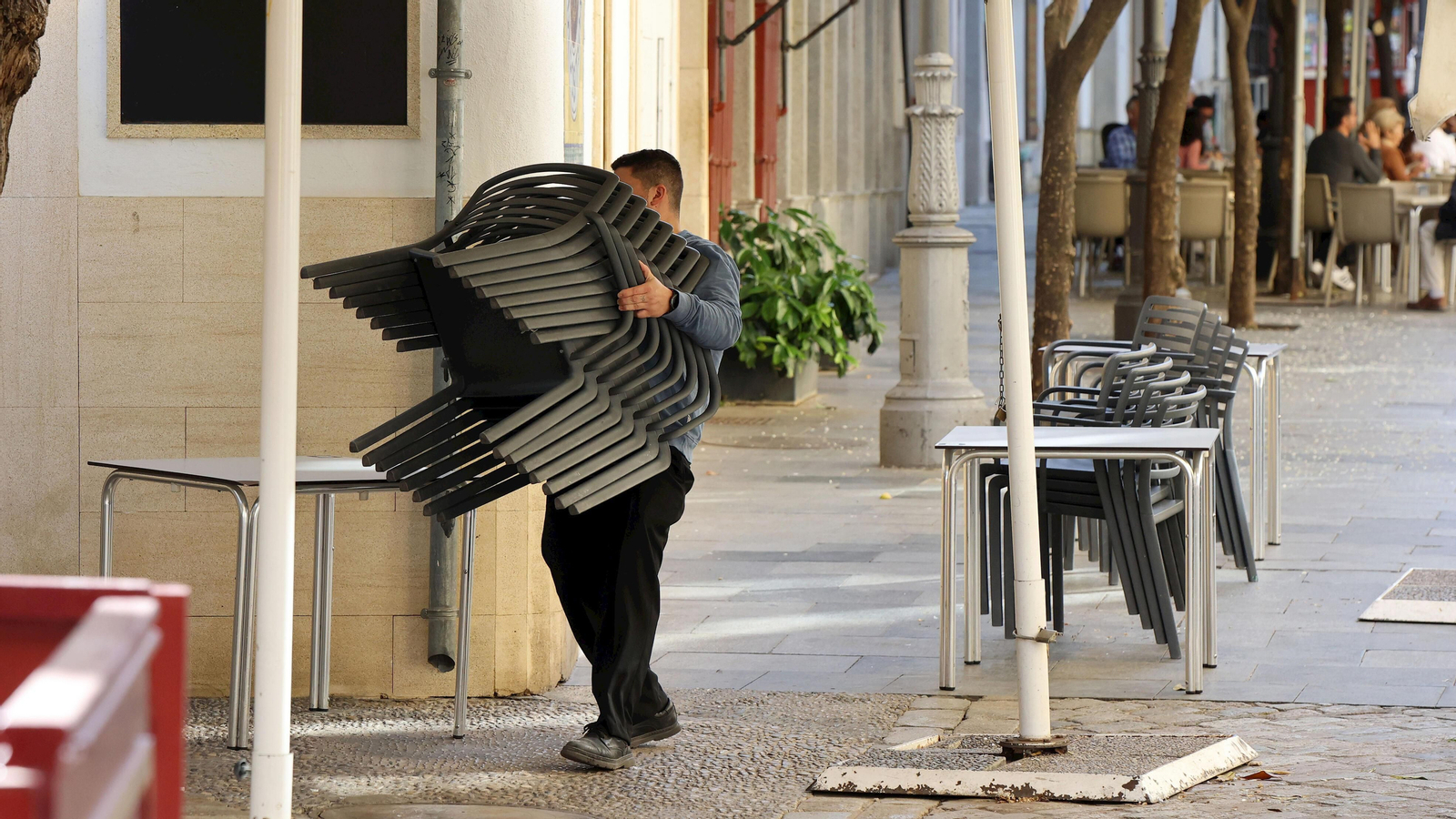 Un camarero recogiendo la terraza de un establecimiento de la calle Consistorio