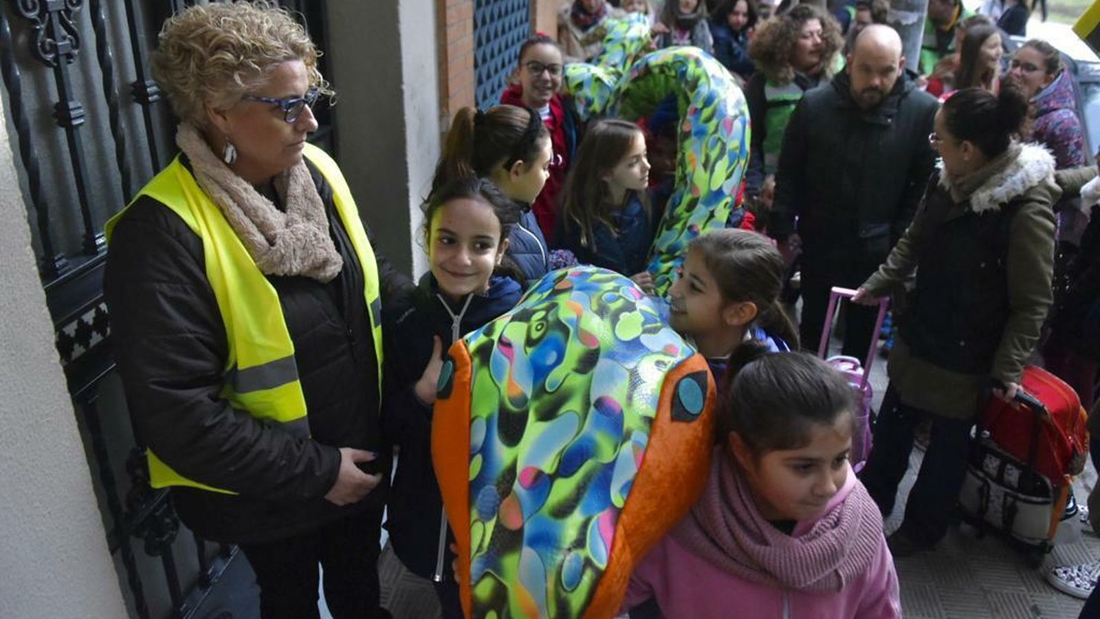 Los menores agarrados a Travis, la serpiente gigante que les acompaña en el camino al cole.