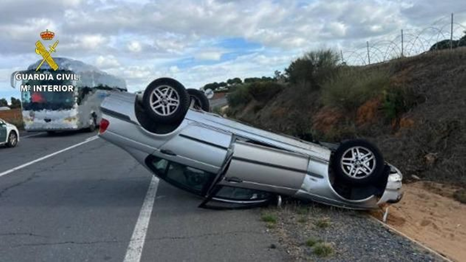 Vehículo volcado tras colisionar con el autobús escolar.