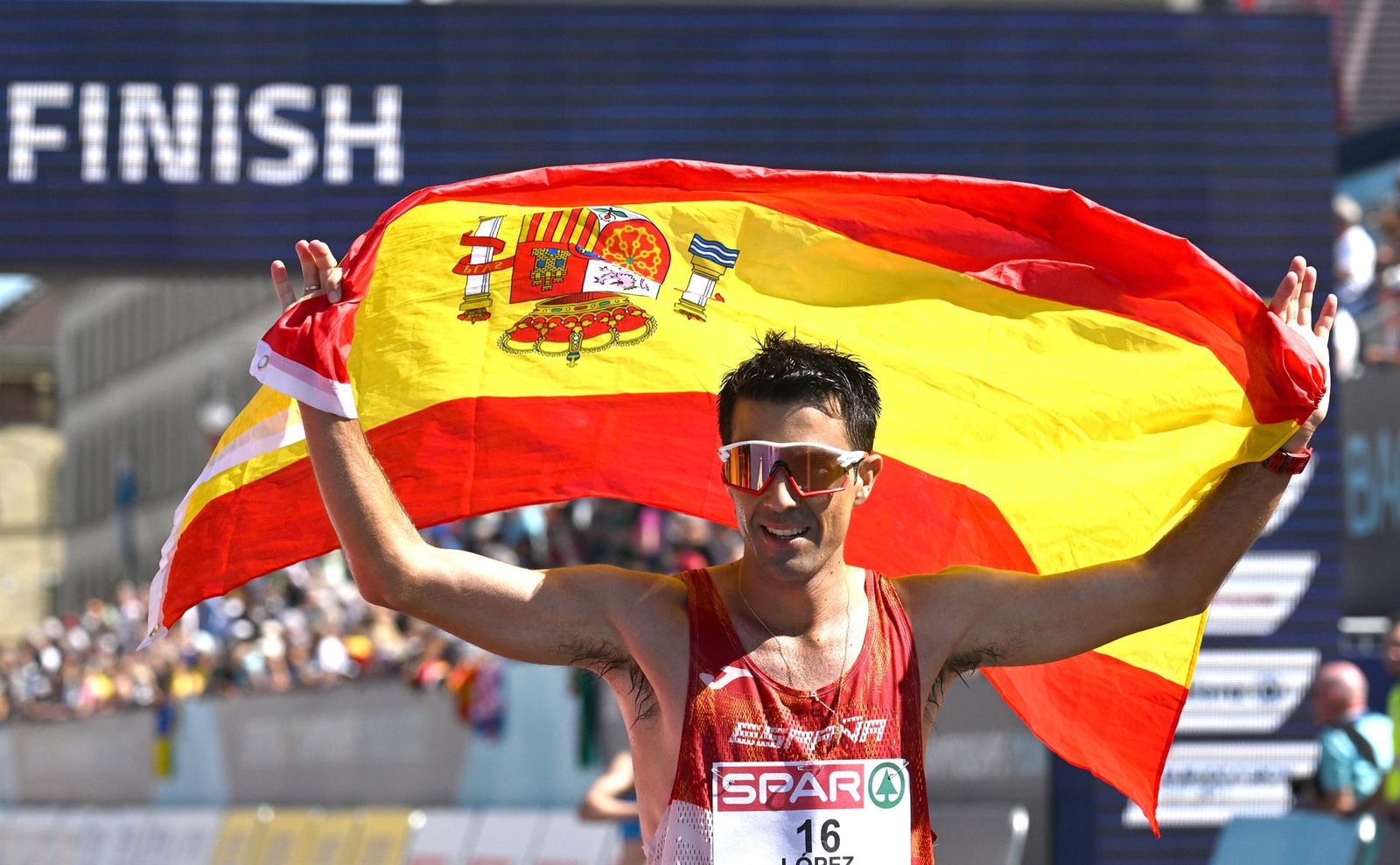 Miguel Ángel López en la meta como campeón con la bandera española.