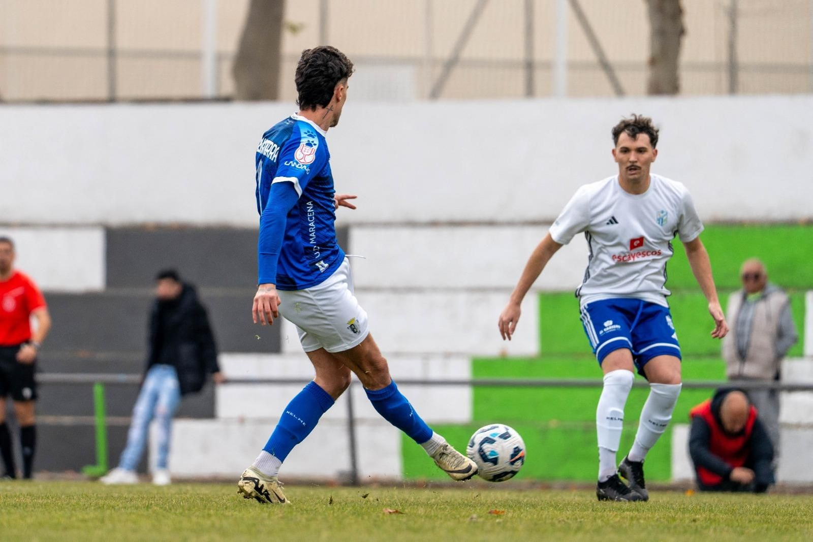 Salvatierra dando un pase ante la atenta mirada de un futbolista del CD Santa Fe.