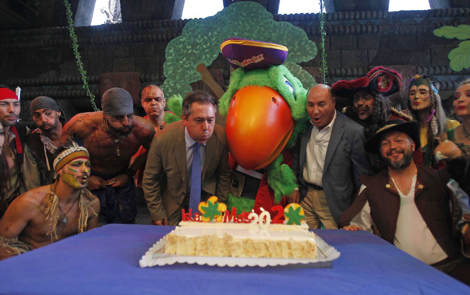 El alcalde y el director de Isla Mágica apagan las velas rodeados de los personajes del parque.