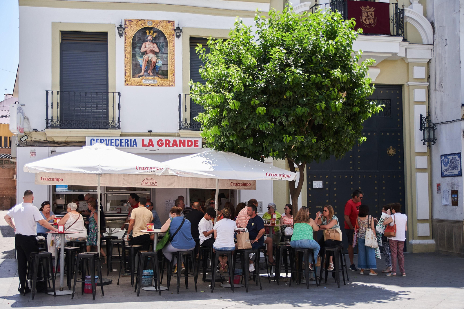 Terraza de veladores repleta de clientes junto a la capilla de La Estrella.