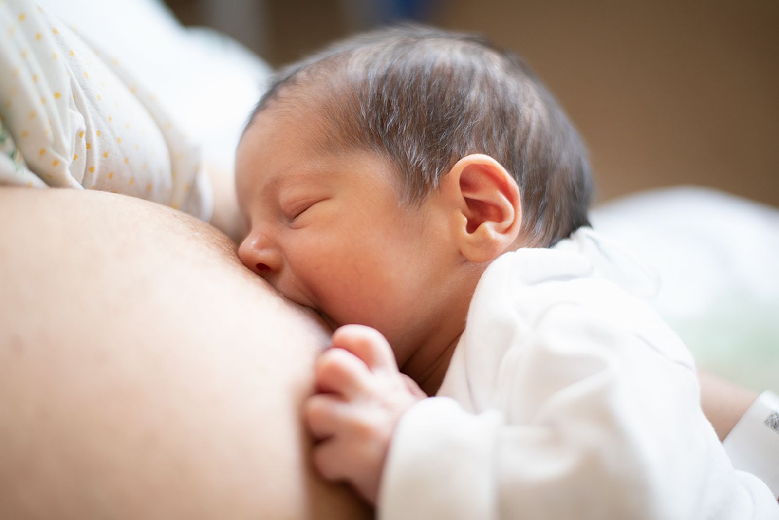 Una mujer, dando el pecho a su bebé