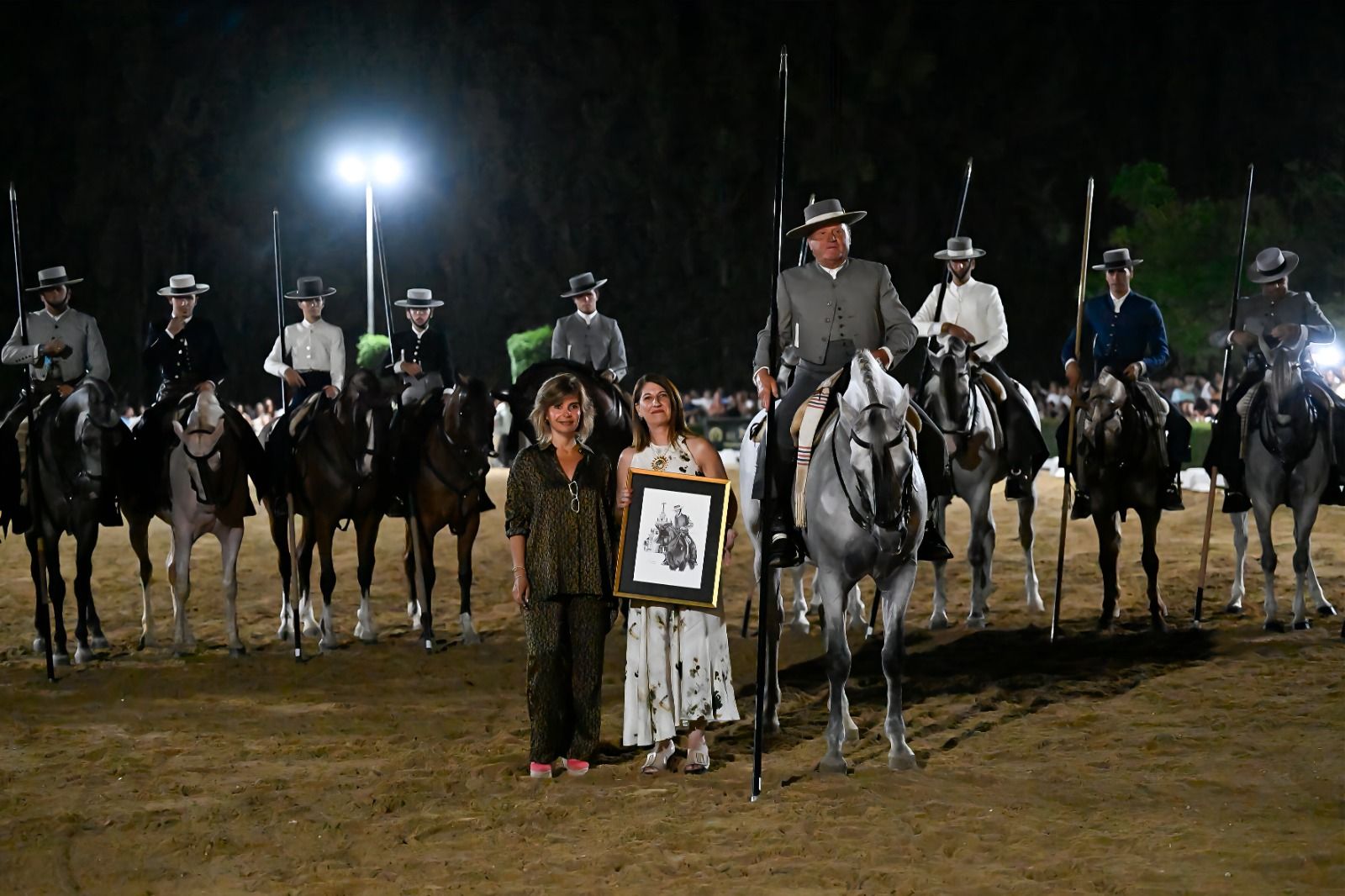 El homenajeado, José Tirado, posa junto con los jinetes participantes en la exhibición, a delegada de Turismo, Cultura y Deporte de Huelva, Teresa Herrera, y Pepa Raso, directora comercial de El Ranchito.