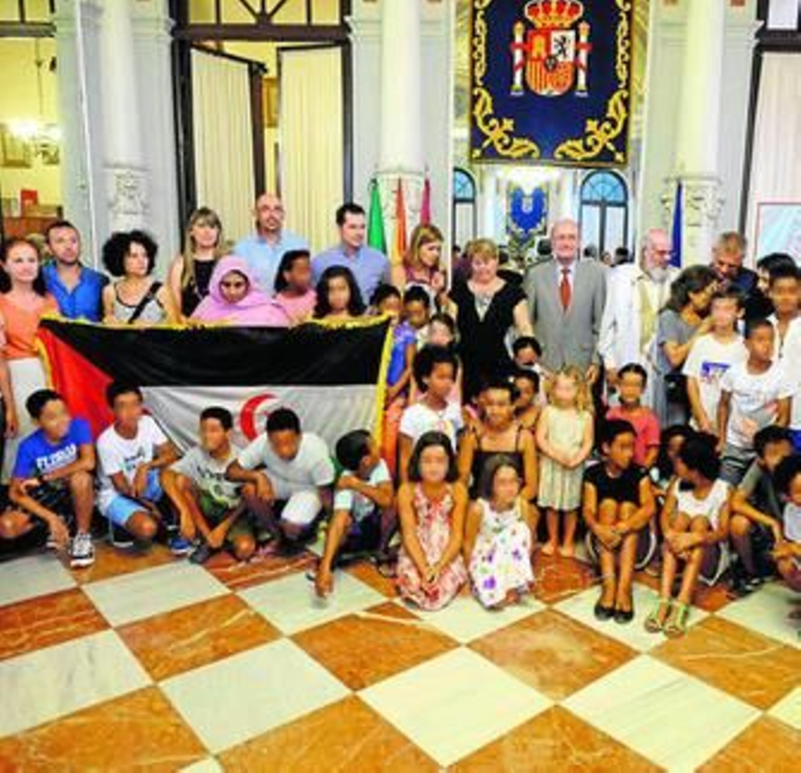 Foto de familia de la corporación municipal con los saharauis acogidos.