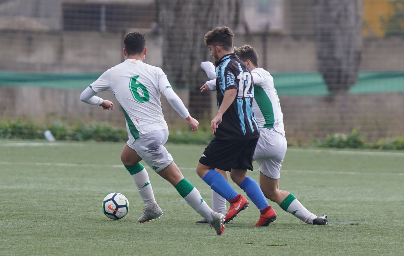 Dos jugadores del Córdoba tratan de cortar el avance de un jugador del Don Bosco.