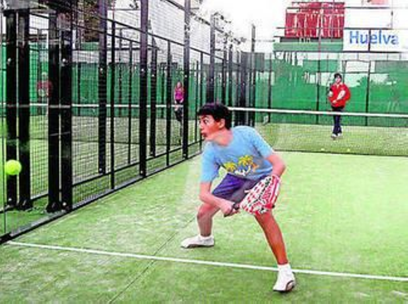 Un jugador se dispone a devolver una bola en un partido de pádel.