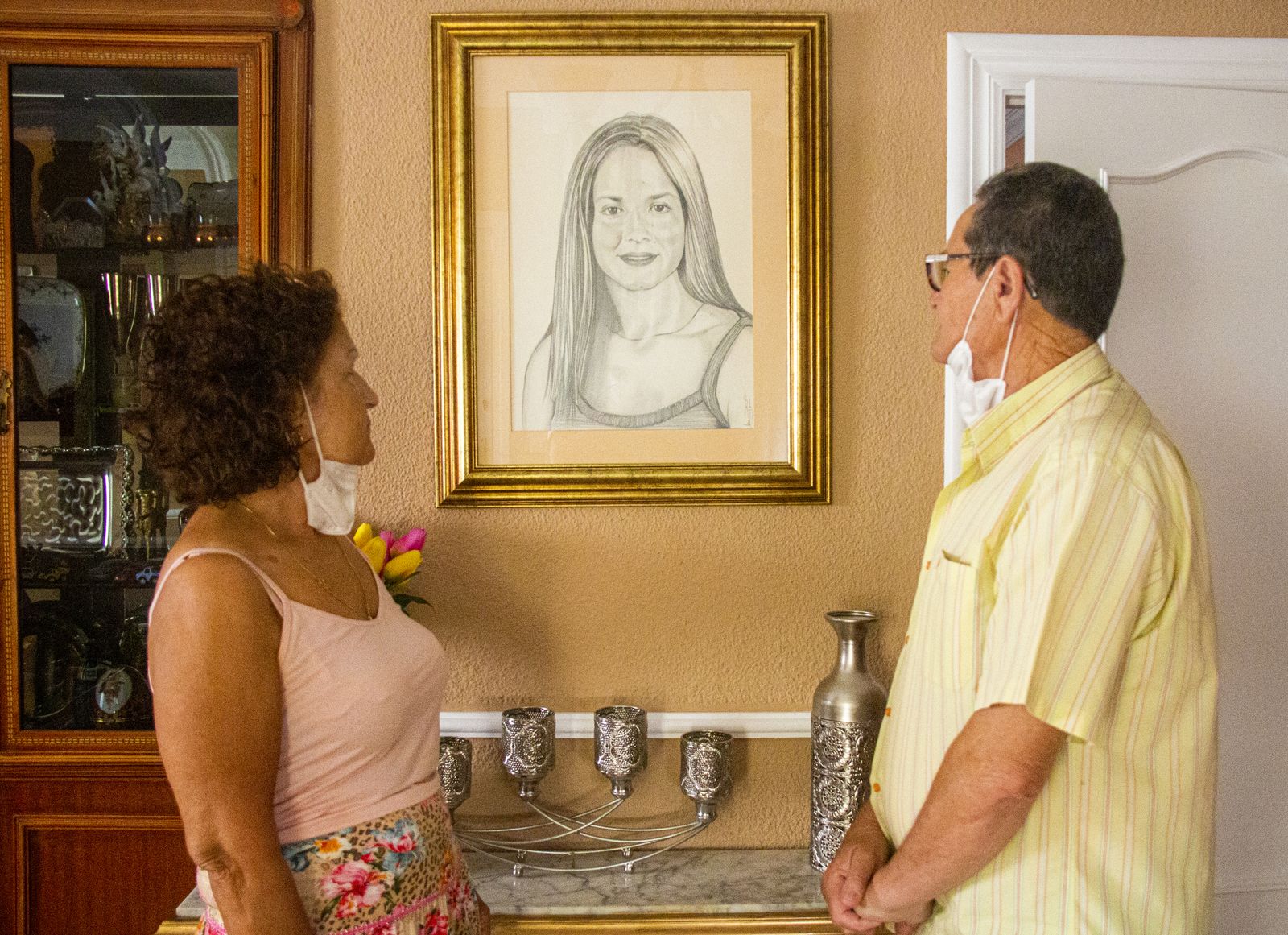 Los padres de María Teresa mirando un cuadro de la joven