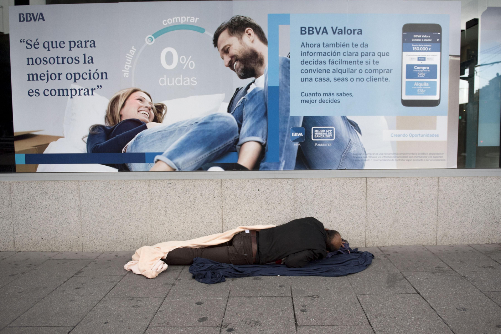 Un sintecho duerme en una calle céntrica de Granada.