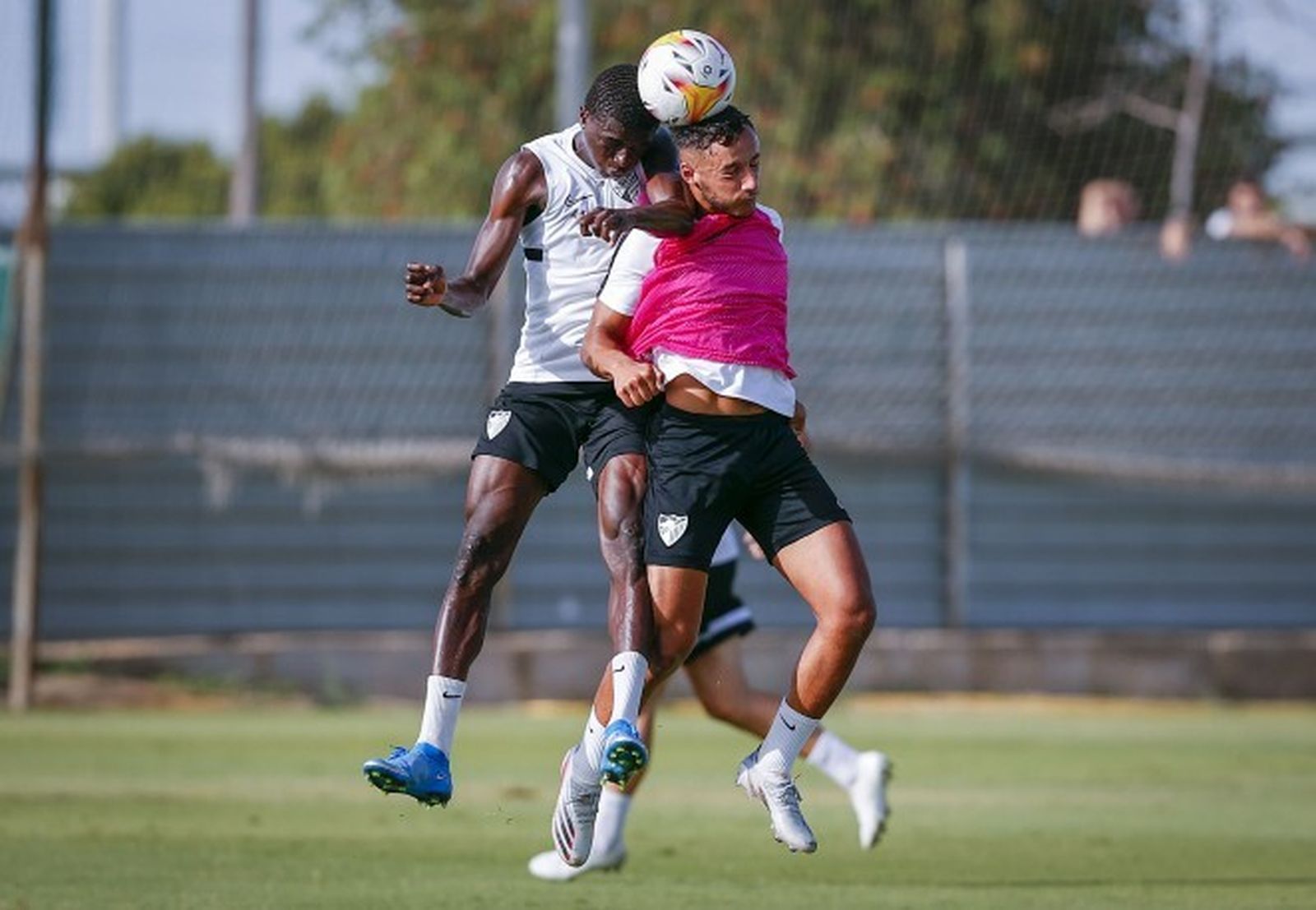 Dos jugadores malaguistas pugna por una pelota en un entrenamiento.