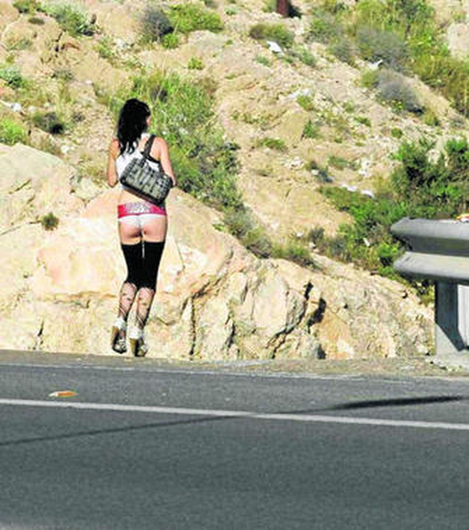 Una prostituta cruza escasa de ropa la carretera del Bayyana.