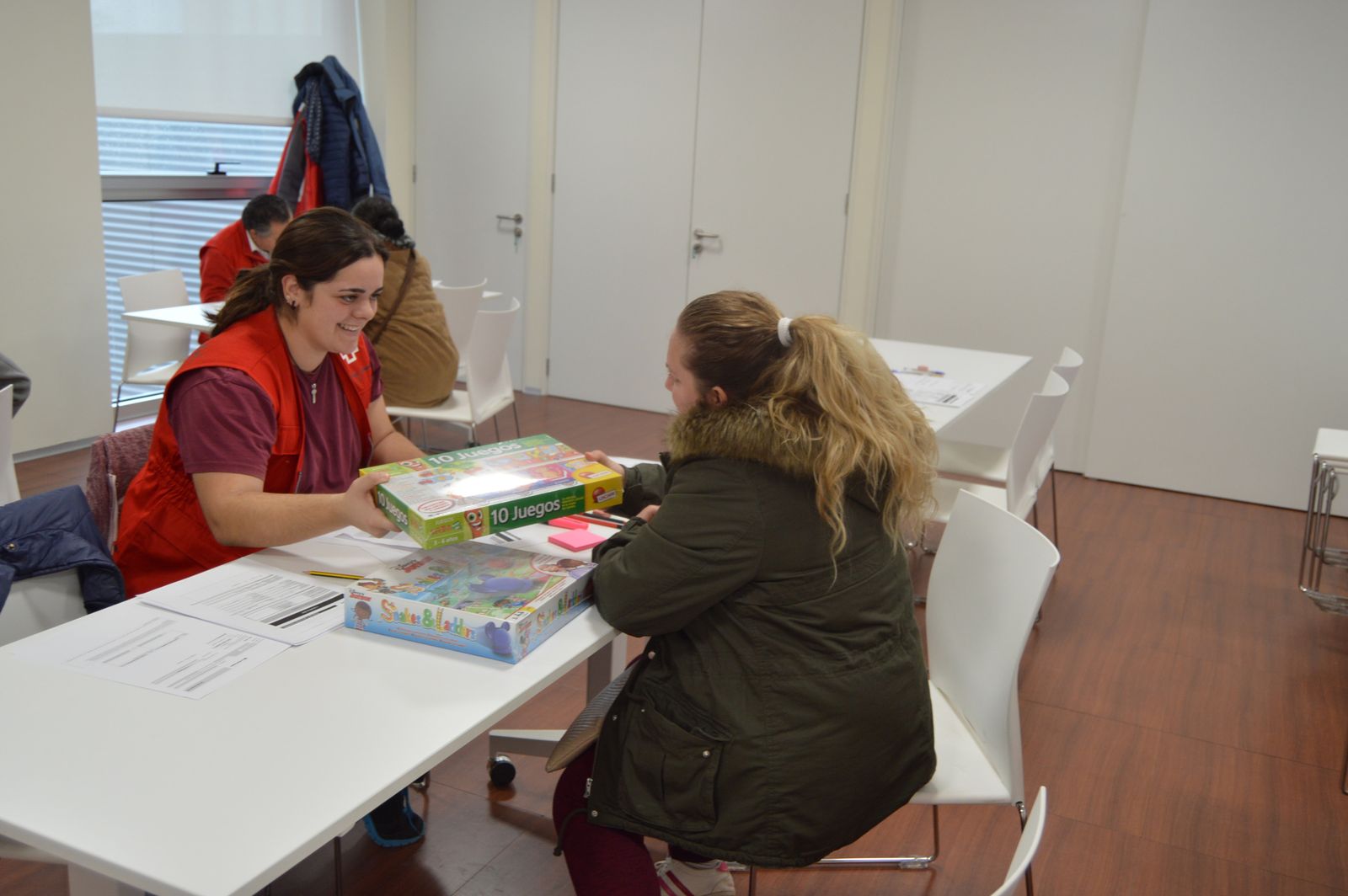 Una técnica de Cruz Roja entrega juguetes a una mujer.