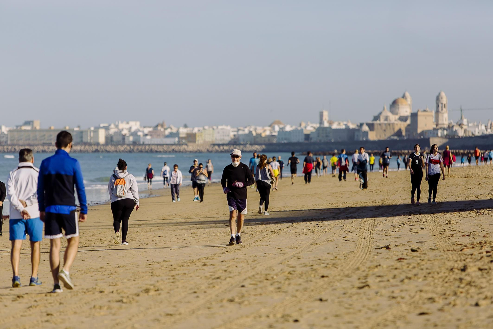 Gente haciendo deporte por la playa