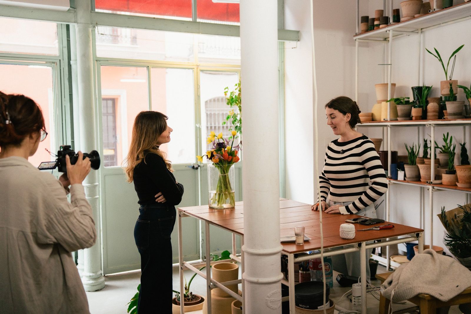La directora Laura Hojman conversa con la floristera Ana Rojas en el establecimiento de Orangerie en Sevilla.