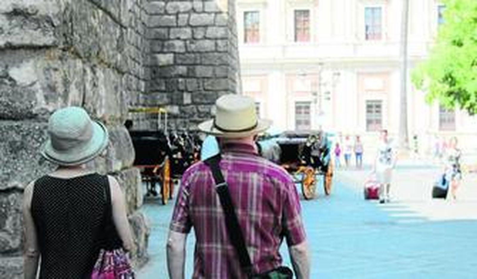 Turistas pasean por Sevilla.