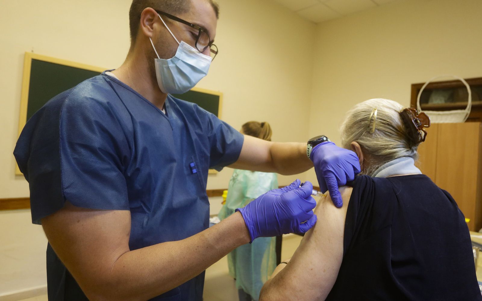 Un enfermero vacuna a una mujer contra la gripe.