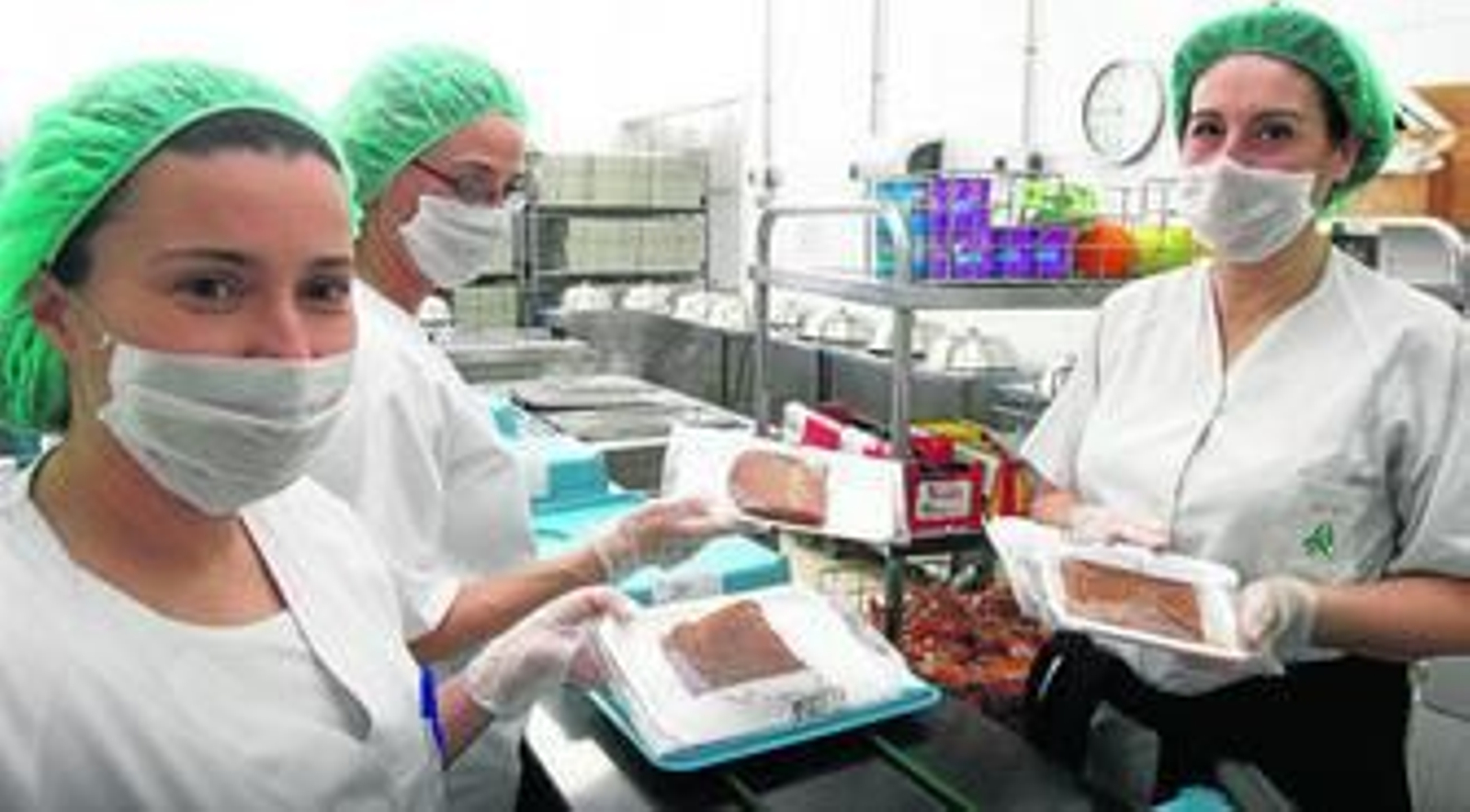 Personal del área de cocina, preparando las meriendas y repartiéndolas en las habitaciones.